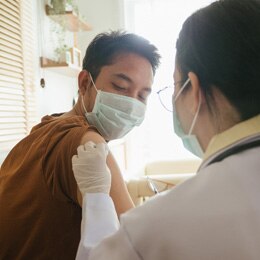 A man getting a vaccine shot from a doctor